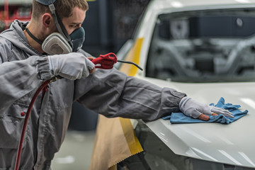 Employee car body painting shop prepares the surface for painting