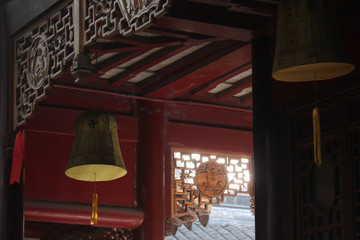 Chinese temple architecture of a hallway with yellow lanterns and decorative and traditional roof top design in the morning sun in China, Asia