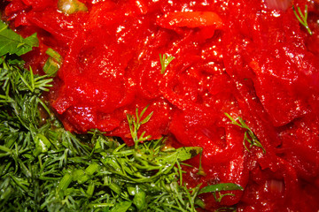 Cut green spicinesses on a background tomato soup..