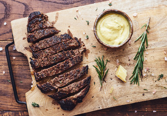 Delicious homemade sliced black angus hot steak with mustard sauce and herbs top view