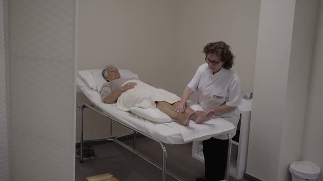 4k footage of acupuncturist manipulating needles inserted to a pacient during an acupuncture treatment in a private clinic