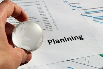 Hand with globe and wrong written word for planning