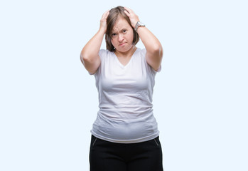 Young adult woman with down syndrome over isolated background suffering from headache desperate and stressed because pain and migraine. Hands on head.