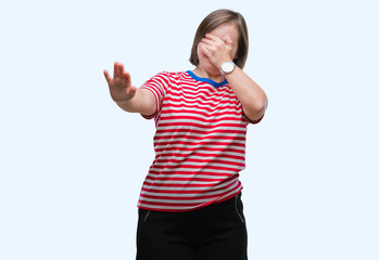 Young adult woman with down syndrome over isolated background covering eyes with hands and doing stop gesture with sad and fear expression. Embarrassed and negative concept.