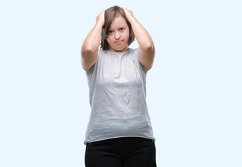 Young adult woman with down syndrome over isolated background suffering from headache desperate and stressed because pain and migraine. Hands on head.