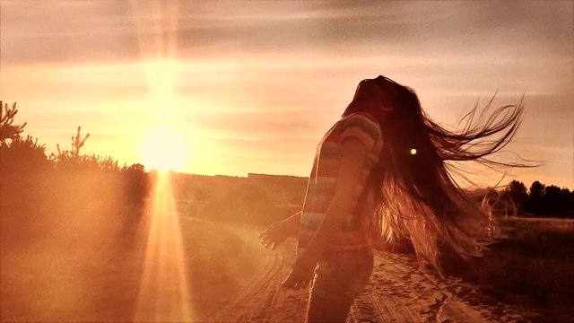 Litttle girl wawing her long hair at sunset, slow motion in retro style