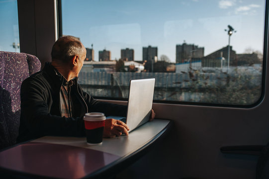 Man Using Laptop And Commuting On Train