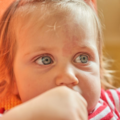 Close up Portrait of blonde baby girl on Orange armchair