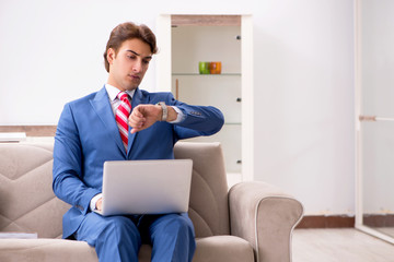 Young businessman working at home sitting on the sofa 