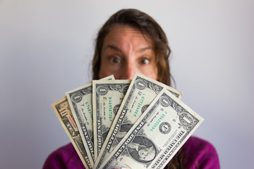 Dollar fan with blurred woman surprised expression on background. Unexpected money inheritance, business wealth, rich entrepreneur, investment concepts