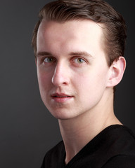 Fototapeta premium Headshot of white caucasian male with green eyes on grey background