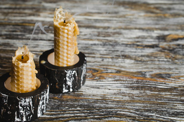 Extinguished wax candles on an old wooden table. Dark mystic background.