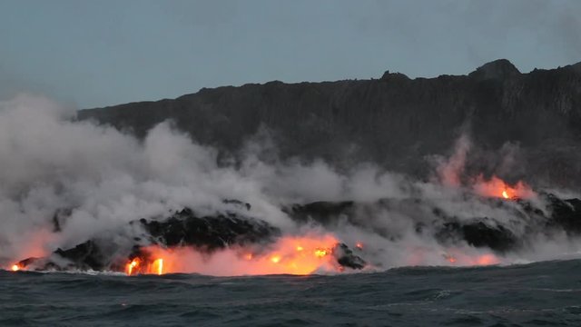 Hawaii Lava flowing into the ocean from lava volcanic eruption on Big Island Hawaii, USA. Lava stream flowing in Pacific Ocean from Kilauea volcano, USA. Seen from water, Steadicam, 59.94 FPS,