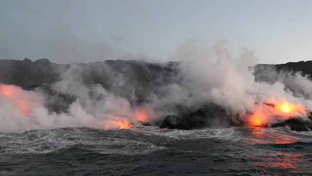 Lava ocean - flowing lava reaching ocean on Big Island, Hawaii. Lava stream seen from the water flowing from Kilauea volcano near Hawaii volcanoes national park, USA. 59.94 FPS, Steadicam.