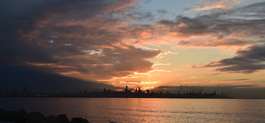 Fototapeta premium panoramic view on Saint Georges Bay at dusk with pink sky and the silhouette of Beirut in a far end on the horizon