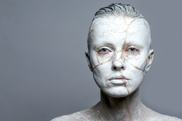 portrait of a woman covered in white clay, aging effect or pottery