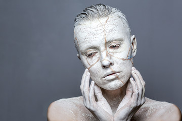 White statue woman covered with clay effect japanese broken jug on face Kintsugi