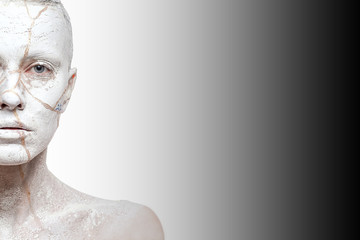 Art portrait of woman covered in clay over ombre white black background