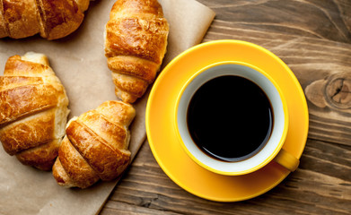 mug of coffee, croissants on wooden background