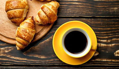 mug of coffee, croissants on wooden background