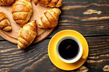 mug of coffee, croissants on wooden background