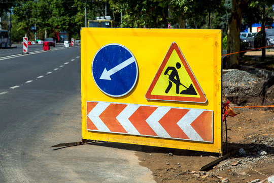 repair work with a warning sign about the detour of a dangerous site with a pit for repairing communications.