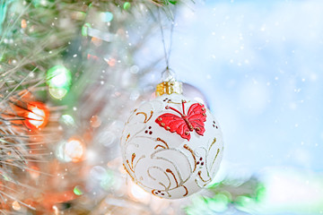 Beautiful Christmas decorations in the form of a white snow globe with a red butterfly