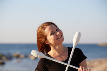 girl gymnast with mace by the sea