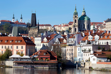 Obraz premium Colorful autumn Prague St. Nicholas' Cathedral with the Lesser Town above River Vltava in the sunny Day, Czech Republic