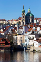 Fototapeta premium Colorful autumn Prague St. Nicholas' Cathedral with the Lesser Town above River Vltava in the sunny Day, Czech Republic
