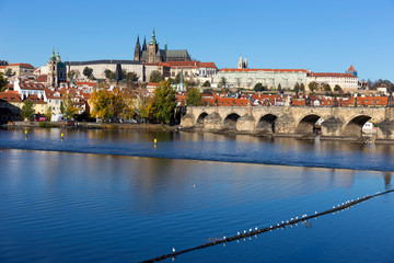Colorful autumn Prague gothic Castle and Charles Bridge with the Lesser Town in the sunny Day, Czech Republic