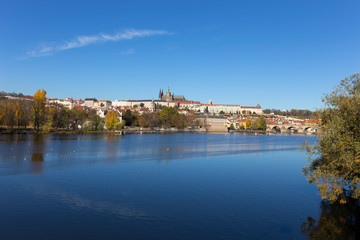 Fototapeta premium Colorful autumn Prague gothic Castle and Charles Bridge with the Lesser Town in the sunny Day, Czech Republic