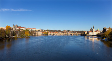 Obraz premium Colorful autumn Prague gothic Castle and Charles Bridge with the Lesser Town in the sunny Day, Czech Republic