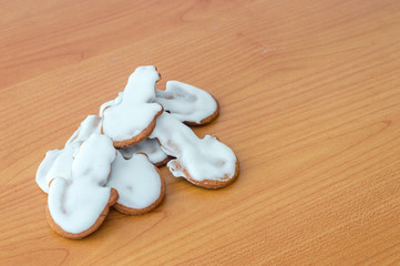 Fototapeta premium Snowman gingerbread cakes with icing for Christmas on wooden table.