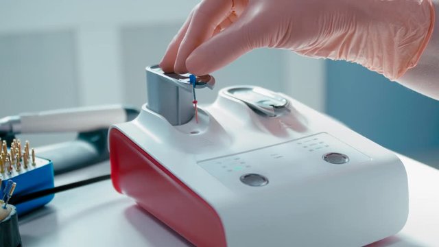 Dentist is Doing Obturation Procedure on Professional Obturator while Training Cleaning and Shaping Dental Root Canals on Glass Sample in Laboratory