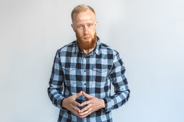 Freestyle. Mature man standing isolated on grey keeping hands steepled looking camera curious