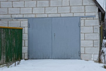 brick garage with metal gates in the snow