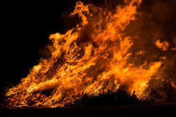 Christmas trees burning on a field at night