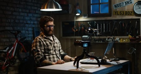 Slow motion shot of young man talking on camera in a garage