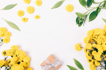Flat lay festive frame of gift box, fresh blooming flowers