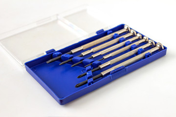 Set of watch screwdrivers in plastic blue box with transparent cover on light background