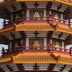 Detailed perspective of a Chinese pagoda decorated with buddha images all around an on all levels in an old town in China, Asia