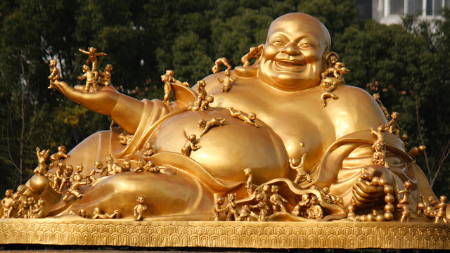Golden buddha image with smaller figurines of children all over the body
