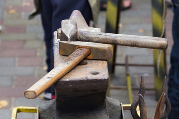 Hammers on the anvil in the street forge workshop.