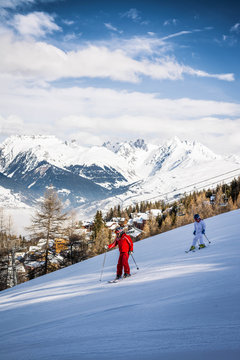 Two people skiing on a ski slope at La Plagne in the French Alps in Savoie, France
