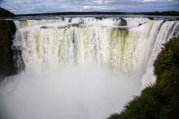 Winter view of Iguazu Falls Devil's Throat under heavy clouds lead sky. Border of Brazil and Argentina. National Park.