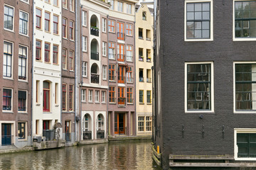 Fototapeta na wymiar View of the old historical buildings near of the one of the water canals in the center part of Amsterdam. Netherlands.