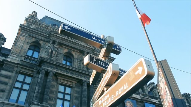 Street Sign With Directions and Louvre Museum in Background, Low Angle View, Paris, France