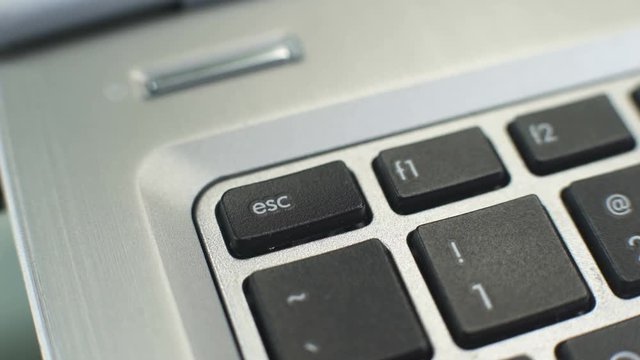 Female hand pressing esc button to generate escape character, stop sign for pc