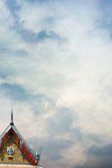 Fototapeta na wymiar The gable of Laos buddhist temple in Luang Prabang and a dramatic sky in the background.